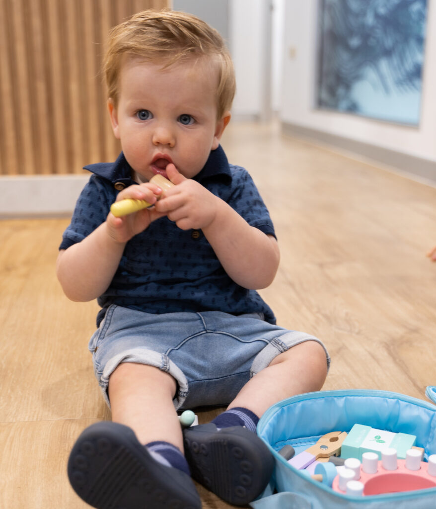 A toddler sits and plays with toys on the spotlessly clean floor in White Dental Co.'s reception area