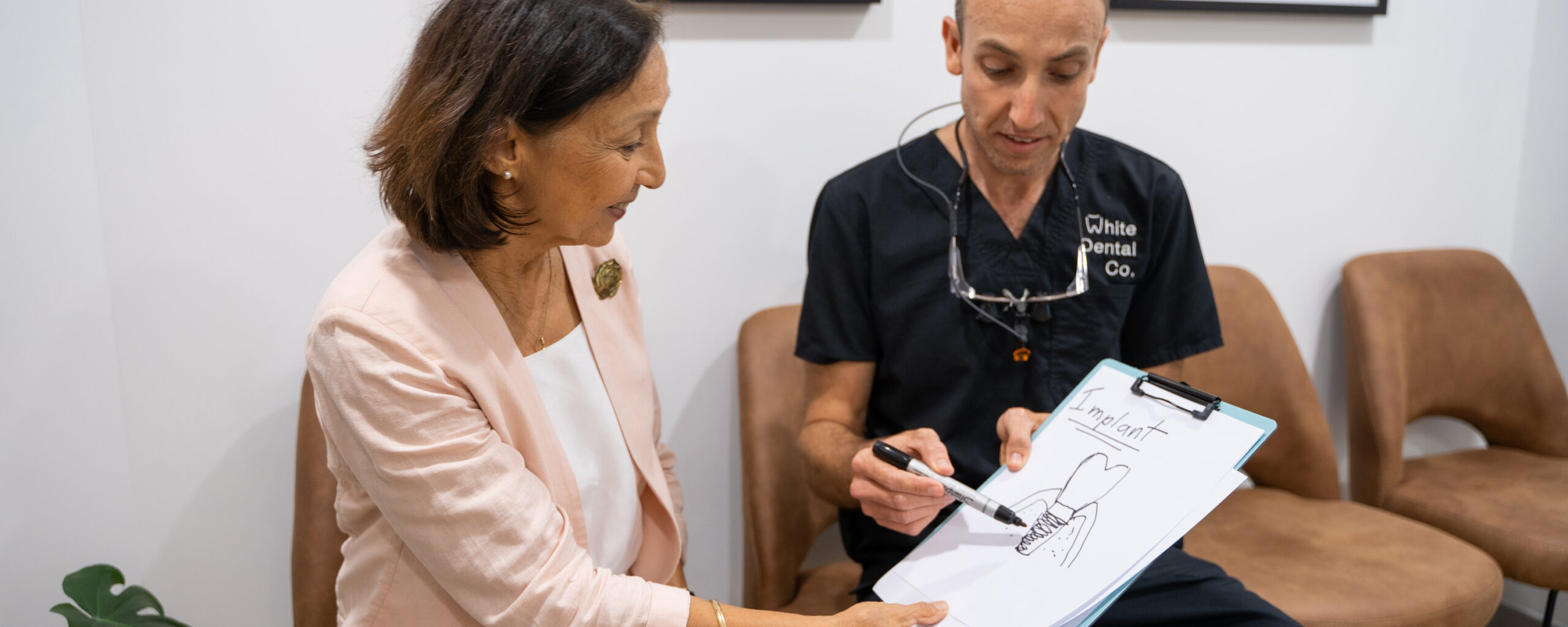 Dr Nick White explaining dental implant treatment to a patient in his rooms in Hervey Bay