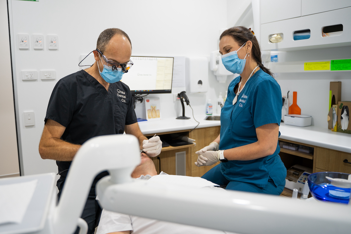 A smile from a young patient and dental assistant, Kelly, at the beginning of an appointment.