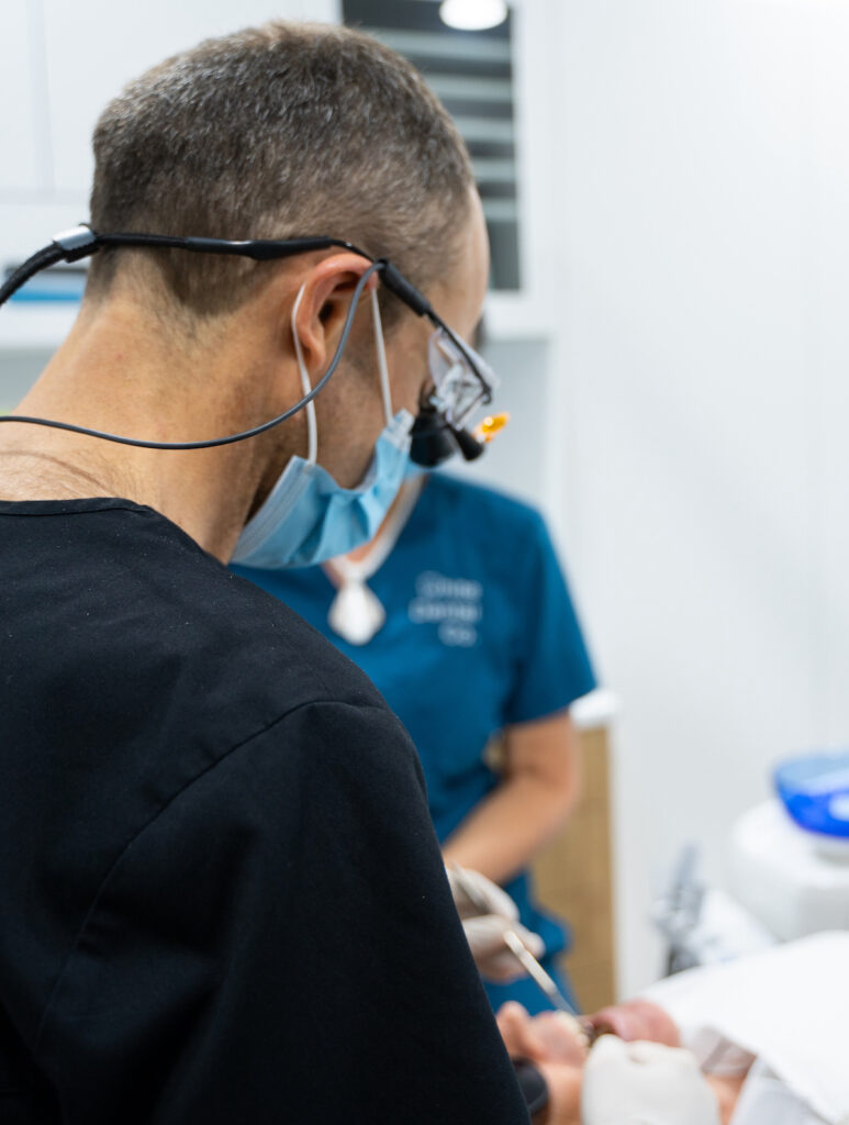 Dr Nick White at work wearing a mask and magnifying loupes.