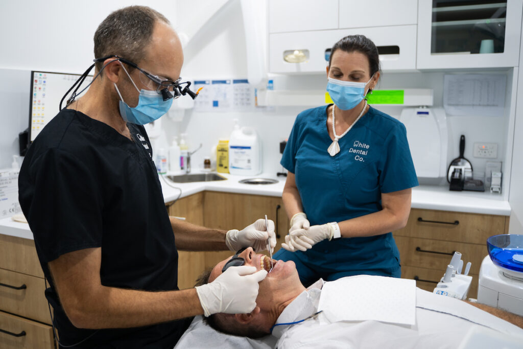 Dr Nick White examines a patient's teeth at White Dental Co in Hervey Bay
