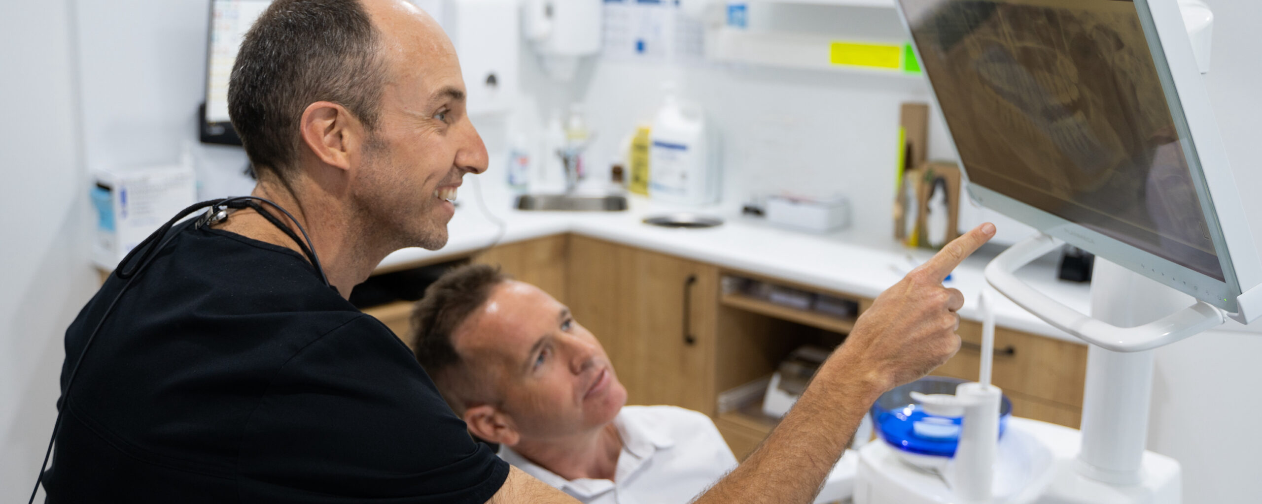 Dr Nick White of White Dental Co. shows a patient an x-ray during a dental checkup