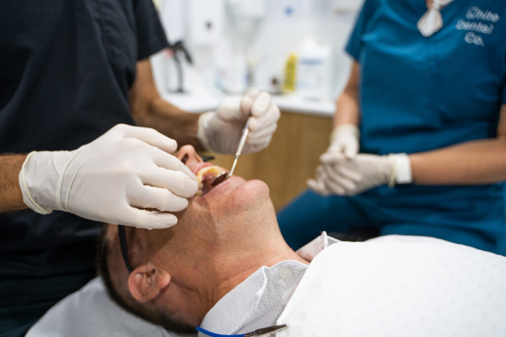 A close-up of a patient having their teeth checked during a preventive dentistry appointment at White Dental Co.