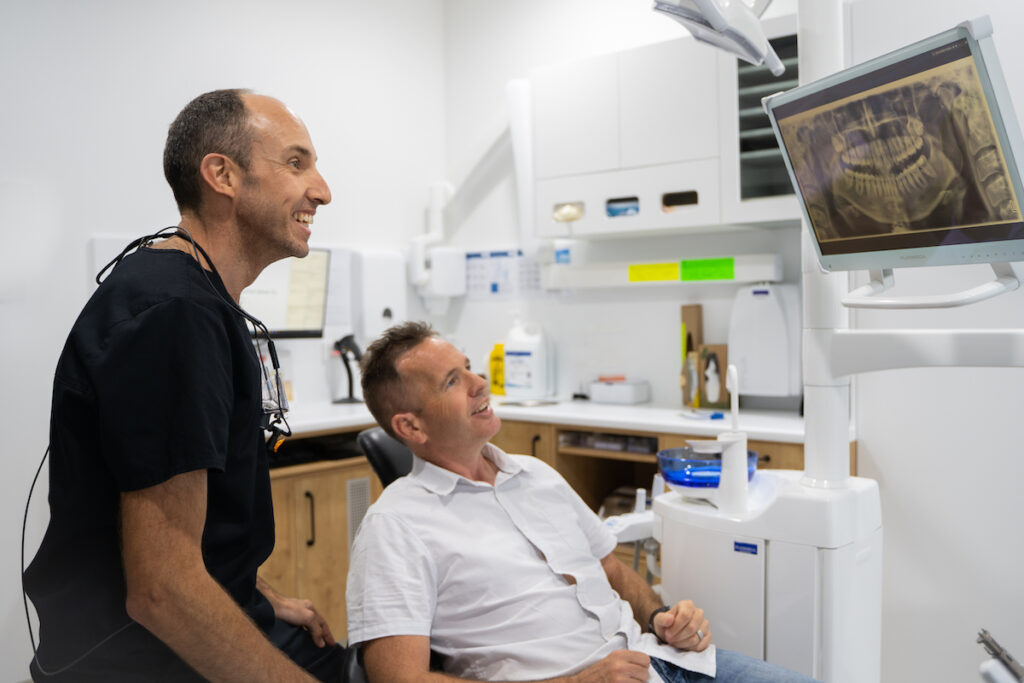 Dr Nick White looks at a dental x-ray with a patient