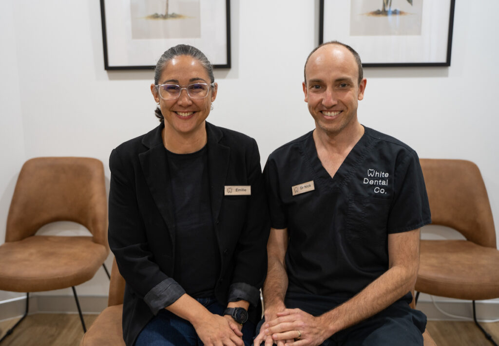 Emilie White and Dr Nick White sit next to each other on comfortable chairs in the White Dental Co. reception area.